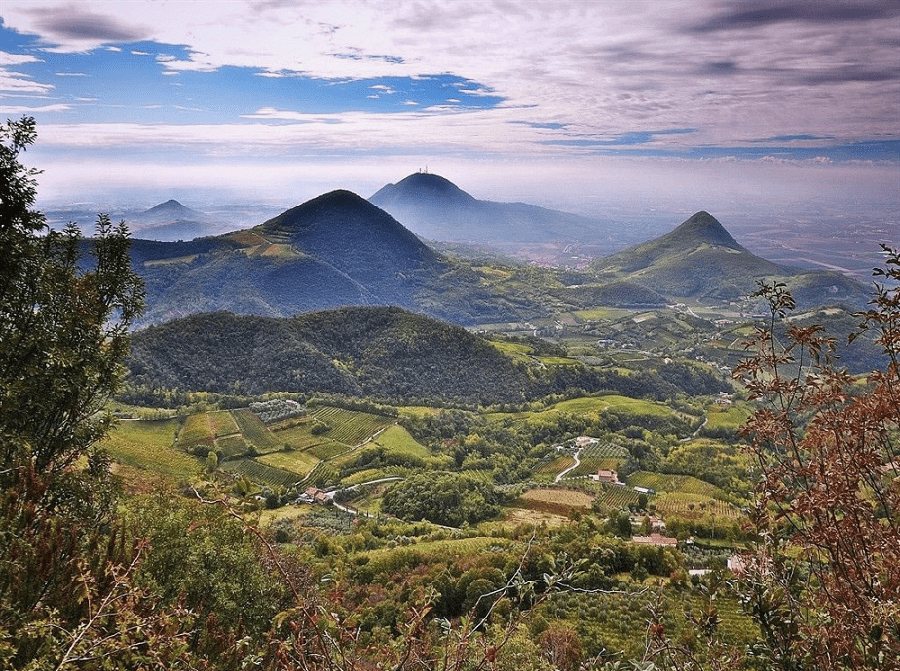 I coni vulcanici dei Colli Euganei visti dall'alto, con vigne, oliveti e la pianura nella foschia
